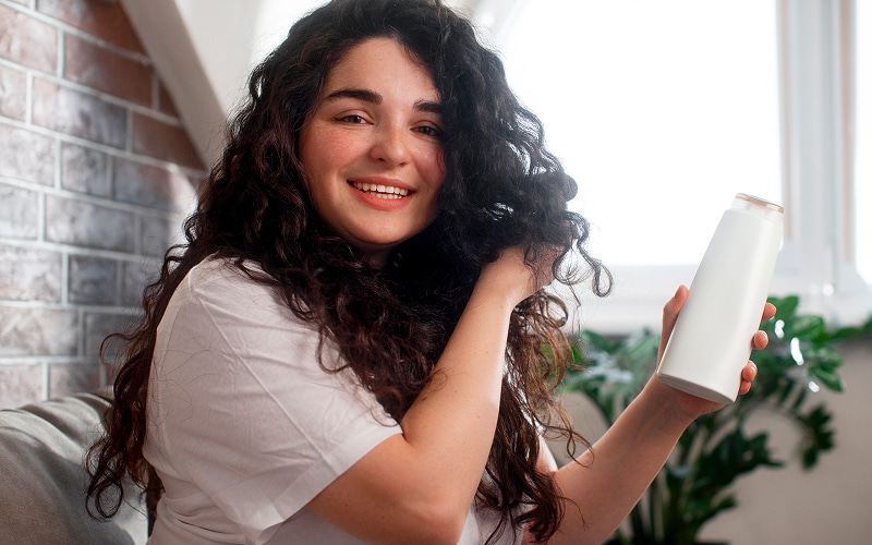 Image of a person applying hair cream to curly hair