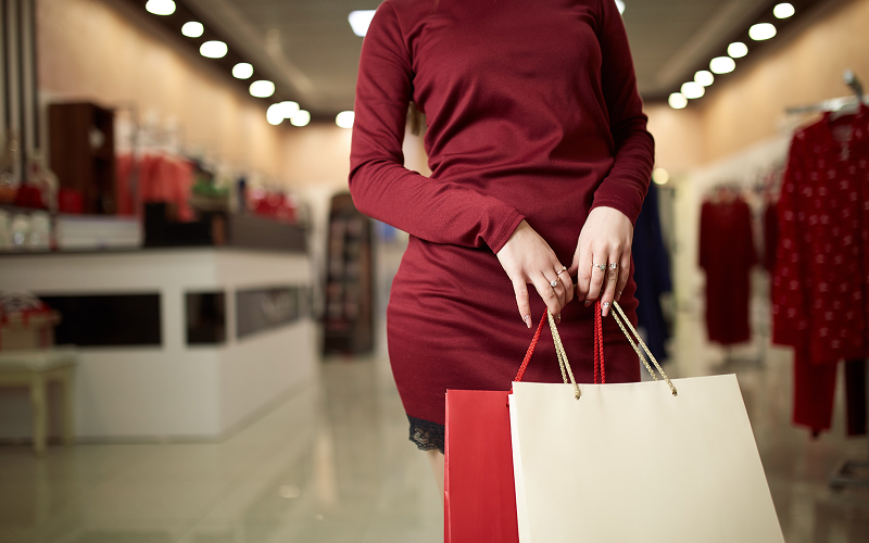 A luxury shopping bag being carried out of a boutique