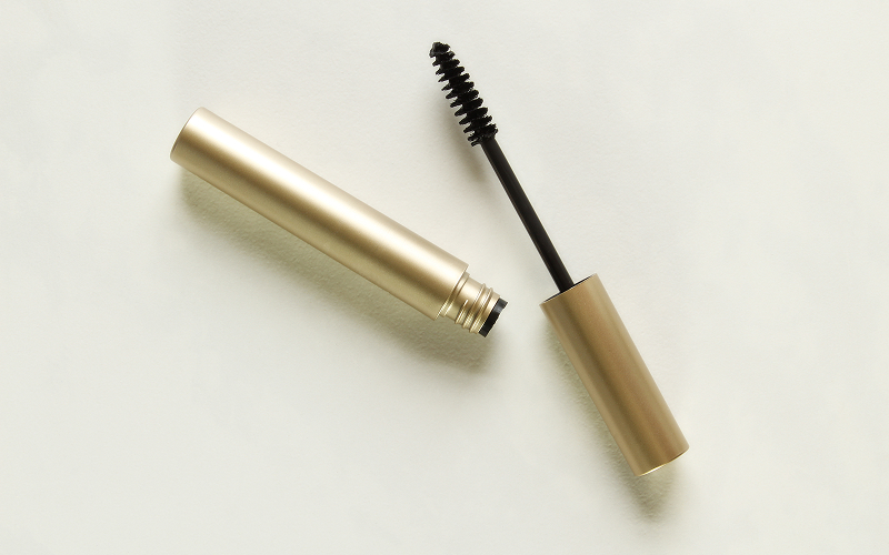 A stock photo of an eye makeup flatlay with lash serum.