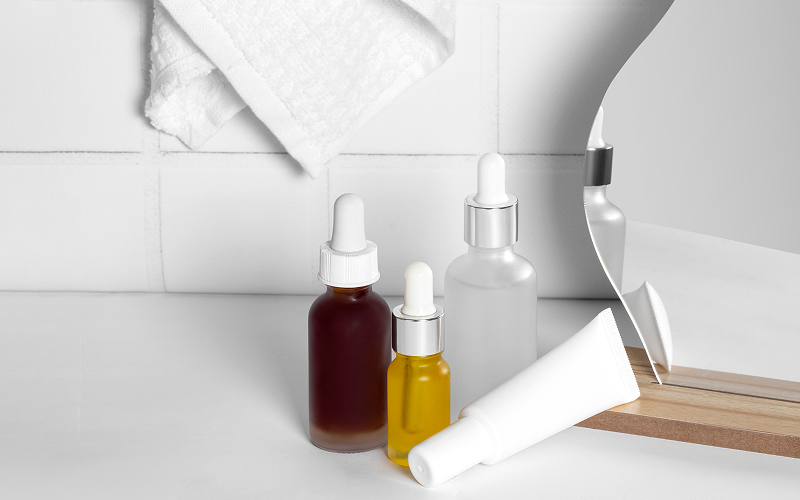 A stock photo of serums and toners shown in a bathroom.