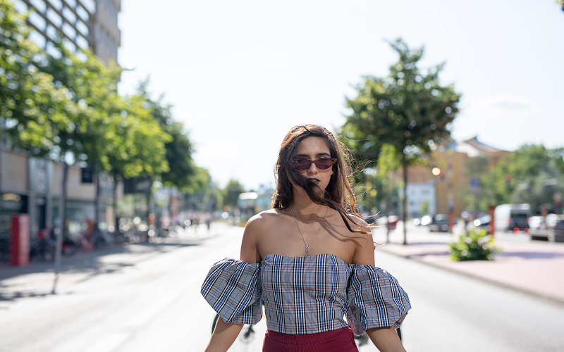 An image of a woman walking under the heat in the city.