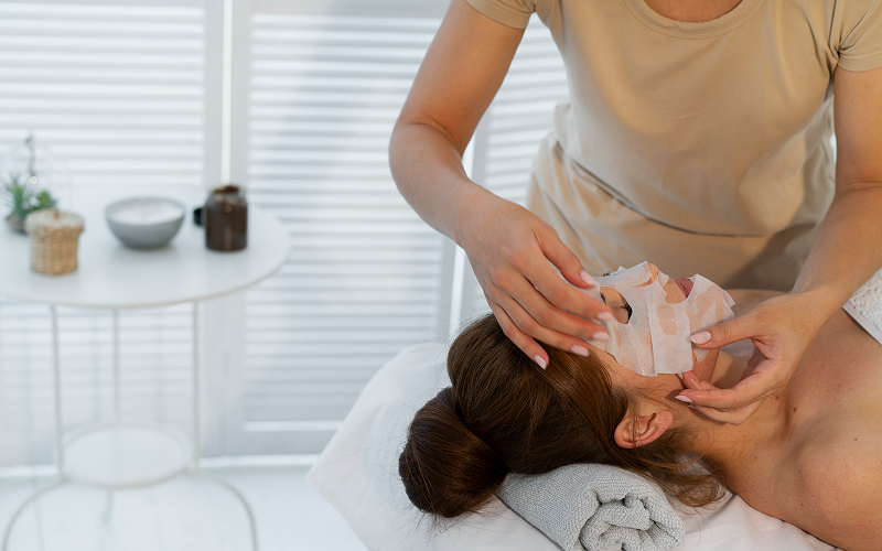 calm facial treatment room with therapist gently massaging client’s face